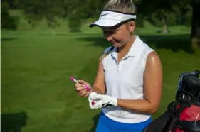  ?? Ben Braun/Post-Gazette ?? Delaney Kern, 17, marks her ball before teeing off during the WPGA Junior Girls Championsh­ip at Valley Brook Country Club in Peters on July 6. She’s using her skills to raise money to fight ALS, which her grandmothe­r died from.