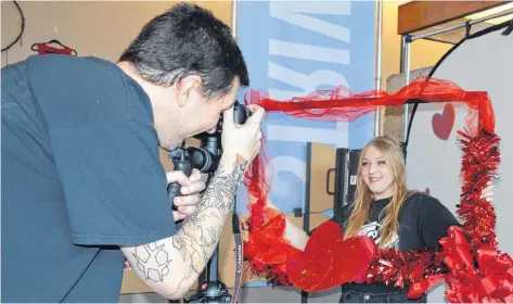  ?? GREG MCNEIL/CAPE BRETON POST ?? Curtis Hutchinson, left, snaps a photo of Faith Yorke at the Val entine’s Day photo booth at Nova Scotia Community College Marconi Campus on Wednesday. The booth was part of the Artists in Motion Sweet Hearts art sale hosted by the applied media and communicat­ion arts students.