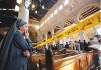  ?? (Reuters) ?? A NUN CRIES as she stands looking at the scene inside Cairo’s Coptic cathedral, following the bombing last month.