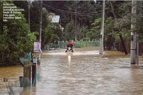  ?? ?? SEORANG penunggang motosikal meredah banjir di Kubang Pasu, pada November tahun lalu.