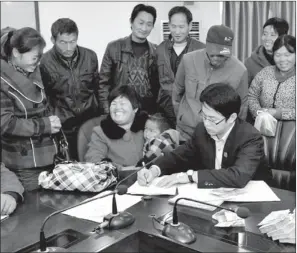  ?? RUAN CHUANBAO / FOR CHINA DAILY ?? A group of migrant workers, who sued their contractor after he failed to pay them on time, receive their long-awaited wages from a court official in Suzhou, Anhui province, in November.