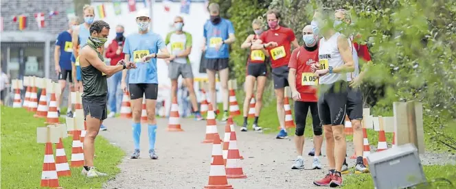  ?? BILD: Martin Remmers ?? Uhren-Vergleich: Direkt vor dem Lauf checkt die Schar um Georg Diettrich (vorn rechts) und Patrick Dekorsi (vorn links) die Smart Watches.