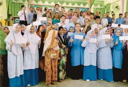  ??  ?? MAHDZIR (tengah) bersama waris dan pelajar yang menerima biasiswa RISDA di Sekolah Menengah Kebangsaan Kuala Nerang, semalam.