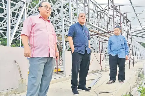  ??  ?? Awang Tengah (centre) and Sum (left) inspect a school upgrading project using the IBS system at SRK Batu Lima which is behind schedule.