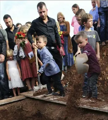  ?? Marco Ugarte/Associated Press ?? Children shovel dirt into the grave that contains the remains of Christina Langford Johnson, the last victim of a cartel ambush that killed nine American women and children earlier this week, during a burial service in Colonia LeBaron, Mexico.