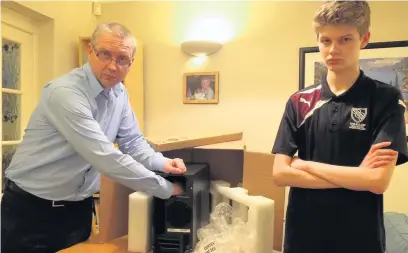  ??  ?? ●● Stephen Knight and autistic son Luke with the gaming PC they claim was incomplete