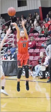  ??  ?? Senior Lady Blackhawk Katelyn Swope (No 11) shot from behind the arc for a 3-point basket Friday as head coach Heath Neal watched.