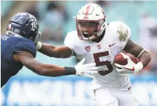  ?? Cameron Spencer / Getty Images ?? Stanford’s Connor Wedington, who is third on the team with 25 catches, stiff-arms a Rice defender in the season opener.