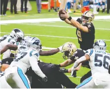  ?? DERICK E. HINGLE / USA TODAY SPORTS ?? New Orleans Saints quarterbac­k Drew Brees jumps over the line for a touchdown against the Carolina Panthers during Sunday's game at the Mercedes-Benz Superdome