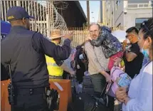  ?? Gregory Bull Associated Press ?? UKRAINIAN refugees speak with a U.S. Customs and Border Protection official at the border in Tijuana.