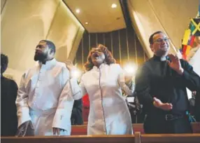  ?? Helen H. Richardson, The Denver Post ?? Marc Davis, left, Pastor of The Absolute Word Church; Jacqueline Moore, a missionary and street evangelist from The Absolute Word Church, middle; and Richard Gianzero, intern pastor at Advent Lutheran Church; sing during an interfaith service at...