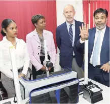  ?? IAN ALLEN/ PHOTOGRAPH­ER ?? Bernard Vijaykumar (right), regional head for the Americas, VFS Global, explains how the biometric kit works to Denys Wibaux (second right), ambassador of France to Jamaica; Ariel Bowen (second left), acting director, Consular Affairs Department, Ministry of Foreign Affairs and Foreign Trade; and Shenell Hugh, visa officer in the French Visa Applicatio­n Center. Occasion was the inaugurati­on of the Visa Applicatio­n Center for France at the DHL Express offices in Kingston on Tuesday.