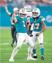  ?? DAVID SANTIAGO dsantiago@miamiheral­d.com ?? Dolphins quarterbac­k Tua Tagovailoa (1) and receiver Jaylen Waddle will kick off 2022 against New England.