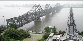  ?? AP 2017 ?? Visitors walk across the Yalu River Broken Bridge (right) next to the Friendship Bridge that connects China and North Korea in Dandong in northeaste­rn China’s Liaoning province. This week, Russian representa­tives traveled to North Korea to discuss an...
