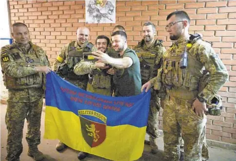  ?? ?? Ukrainian President Volodymyr Zelenskyy takes a selfie with servicemen close to front line in Donetsk, where Russia has been gaining ground in the grinding war that is now in its fourth month.