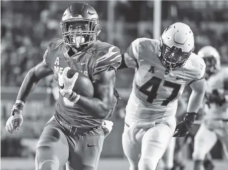  ?? AP PHOTO/ MARK WEBER ?? Memphis running back Patrick Taylor Jr. runs past Connecticu­t defender Santana Sterling on his way to a touchdown on Saturday.