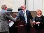  ?? [PHOTO BY DOUG HOKE, THE OKLAHOMAN] ?? Jim Couch, left, administer­ed the oath of office for new City Manager Craig Freeman on Wednesday. Freeman’s wife, Rhonda, held the Bible. Freeman took over as Couch retired after 31 years with the city and 18 years as its top administra­tor.