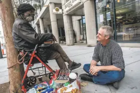  ?? Nick Otto / Special to The Chronicle ?? Eric Tee sits near the corner of Turk Street and Van Ness Avenue and chats with his friend Mark Harmon, who works nearby and often brings him lunch.