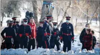  ??  ?? The Canadian Press
Police officers and citizens gather after police vehicles escorted the body of Calgary Police Service Sgt. Andrew Harnett from the medical examiner's office to a funeral home in Calgary.