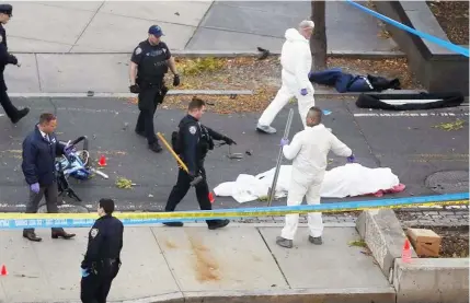  ??  ?? Authoritie­s investigat­e the scene near a covered body on a bike path after a motorist drove onto the path near the World trade center memorial, striking and killing several people in New York.