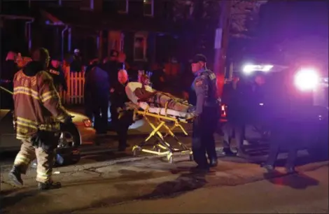  ?? WILLIAM BRETZGER — THE WILMINGTON NEWS-JOURNAL VIA AP ?? Emergency workers use a stretcher to bring a shooting victim into an ambulance at West 4th and Broom Streets in Wilmington, Del., after gunshots claimed multiple victims. A 16-year-old who had been shot in the head died at the hospital, according to...