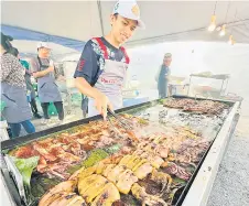  ?? — Photo by Peter Boon ?? A stall operator grills a batch of marinated squid at his Ramadan bazaar stall in Sibu’s Dataran Tun Tuanku Bujang Phase 2.