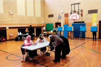  ?? — AFP photo ?? Voters check in at a polling location during the Michigan presidenti­al primary in Dearborn, Michigan.