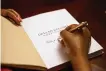  ?? YORK TIMES NORA WILLIAMS/THE NEW ?? Emily Meggett, the author of “Gullah Geechee Home Cooking,” signs a copy of her new cookbook at Buxton Books in Charleston, S.C., April 29.