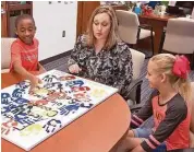  ?? R. Clayton McKee/ For the Chronicle ?? Frostwood Elementary pupil Daniel Patterson, principal Ellen Green and pupil Madeline Besetsny, talk about an anti-bullying painting project.