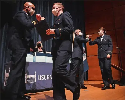  ?? PHOTOS BY DANA JENSEN THE DAY ?? First-class Cadet Mikael Axelson fistbumps Capt. Arthur Ray, commandant of cadets, after receiving his billet Thursday while firstclass Cadet Salena Bantz receives a fist-bump from Capt. Rick Wester, assistant commandant, during billet night at Leamy Hall on the Coast Guard Academy campus in New London. Axelson, Bantz and their fellow Cadets Aidan Uvanni and Drusilla Corbett will head to the Coast Guard icebreaker cutter Polar Star.