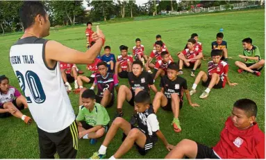  ?? — AFP ?? Pep talk: A filepic showing Nopparat Khantavong, head coach of the ‘ Wild Boars’ football team and his players during a training session at a school in the Mae Sai district of Chiang Rai province.