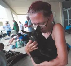  ??  ?? Right, Gloria Van Cleave embraces her cat Midnight on Monday as she prepares to evacuate from Brunswick, Ga. ahead of Hurricane Dorian.