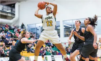  ?? CITIZEN PHOTO BY JAMES DOYLE ?? UNBC Timberwolv­es forward Maria Mongomo leaps to take a shot over a trio of University of Victoria Vikes defenders on Friday evening at Northern Sport Centre.