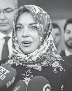  ??  ?? Lohan wears a headscarf given to her by a Syrian woman after visiting Syrian refugees in Turkey last Oct 8. — File photo