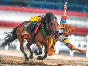  ?? PURBU ZHAXI/ XINHUA ?? A Tibetan horseman proposes a toast in Lhasa, capital of the Tibet autonomous region, on Wednesday. Local riders performed various equestrian feats during Shotan Festival celebratio­ns.