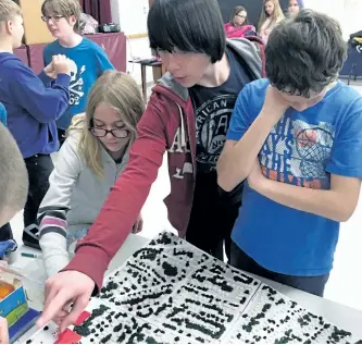  ?? SPECIAL TO THE EXAMINER ?? Grade 7 and 8 students at Highland Heights Public School share stories about their neighbourh­ood during a NeighbourP­LAN Map Chat event at their school. Here, students point out areas of interest on a 3-D model of their neighbourh­ood and share ideas about what works and where improvemen­ts could be made.