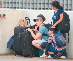  ??  ?? Passengers take cover as first responders secure the area outside the Fort Lauderdale-Hollywood Internatio­nal airport after a shooting