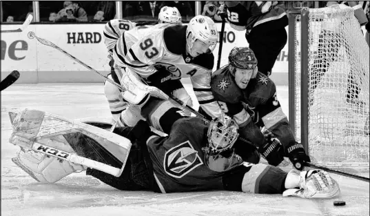  ?? David Becker The Associated Press ?? Knights goaltender Marc-Andre Fleury and defenseman Brayden McNabb block off Oilers center Ryan Nugent-Hopkins on Saturday at T-Mobile Arena. The Pacific Division leaders won 4-2 as Connor McDavid and Leon Draisaitl combined for five points.