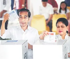  ?? — Reuters photo ?? Widodo and first lady Iriana cast their ballots during elections in Jakarta, Indonesia.