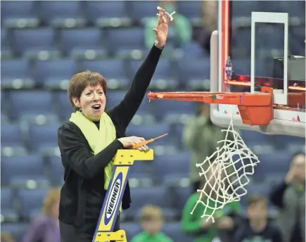  ?? JOE MAIORANA/USA TODAY SPORTS ?? National coach of the year Muffet McGraw cuts a piece of the net after her Notre Dame squad defeated Mississipp­i State 61-58 in the NCAA women’s final Sunday. The victory was No. 800 at the school for McGraw.
