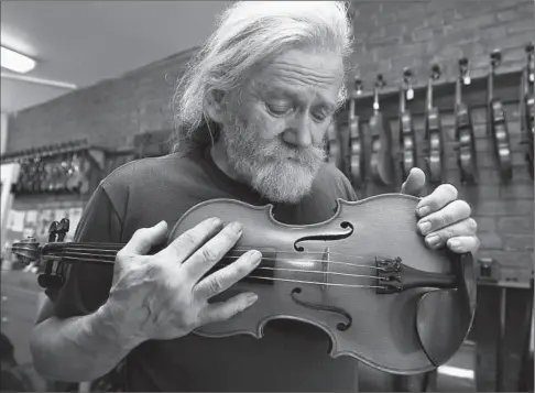  ?? JOHN MAHONEY THE GAZETTE ?? Luthier Gilles Blouin cradles a cherished Anton Wilfer violin: “The truth is it doesn’t take very long to make a violin from start to finish. But it does take between 20 and 30 years to become a good violinmake­r, who has his own style and whose violins...