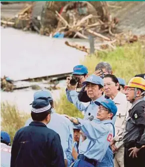  ?? AFP PIC ?? Japanese Prime Minister Shinzo Abe (centre) inspecting a floodaffec­ted area in Hita, Oita prefecture, yesterday.