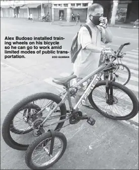  ?? EDD GUMBAN ?? Alex Budoso installed training wheels on his bicycle so he can go to work amid limited modes of public transporta­tion.