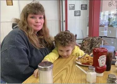  ?? PHOTOS BY JOHN FLESHER — THE ASSOCIATED PRESS ?? Heather Bable and her son Ashton poses for a photograph, Feb. 25, at Sprinklz On Top restaurant in East Palestine, Ohio. Bable and her children live less than a half-mile from where a train derailed in a fiery crash Feb. 3, forcing them to evacuate and raising fears about contaminat­ion of air, soil and water. Bable her family have lived in East Palestine for four generation­s but she says she no longer feels safe there and is seeking a new home.