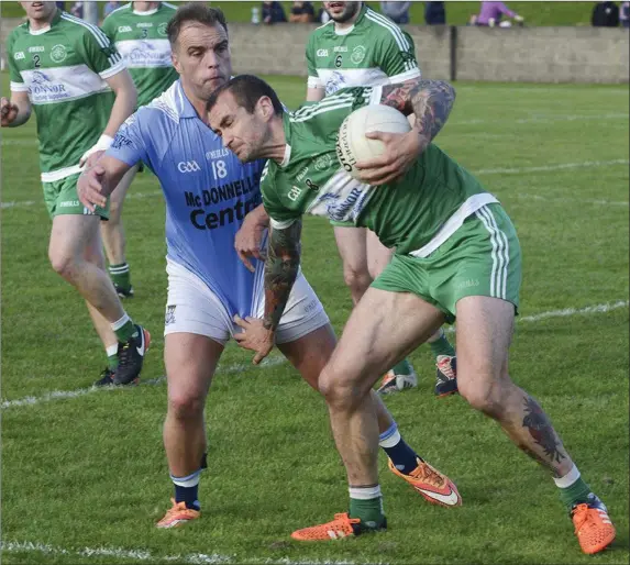  ??  ?? Paddy Keenan holds off Derek Kierans to clear his lines for St Pat’s. Pictures: Jimmy Weldon