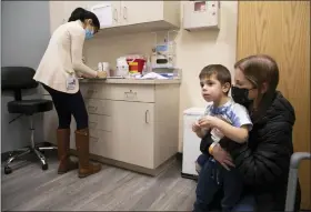  ?? AP PHOTO/EMMA H. TOBIN, FILE ?? Ilana Diener holds her son, Hudson, 3, during an appointmen­t for a Moderna COVID-19 vaccine trial in Commack, N.Y. on Nov. 30, 2021.