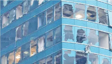  ??  ?? Damaged windows of the One Harbourfro­nt office tower are seen following Typhoon Mangkhut, in Hong Kong. — Reuters photo