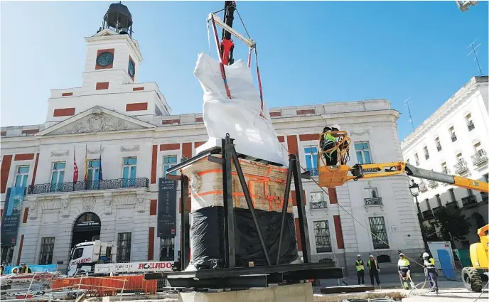  ?? AYUNTAMIEN­TO DE MADRID ?? Varios obreros suben de nuevo la estatua de Carlos III a su pedestal este lunes en su nueva ubicación en la Puerta del Sol