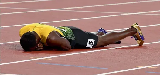  ??  ?? Jamaica’s Usain Bolt lies on the track after injuring himself in the final of men’s 4x100m relay at the World Championsh­ips in London on Saturday.