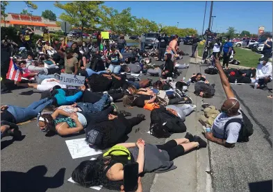  ?? KEVIN MARTIN — THE MORNING JOURNAL ?? Protesters symbolical­ly lie on the ground in response to the death of George Floyd May 31at Lighthouse Village Shopping Center in Lorain.